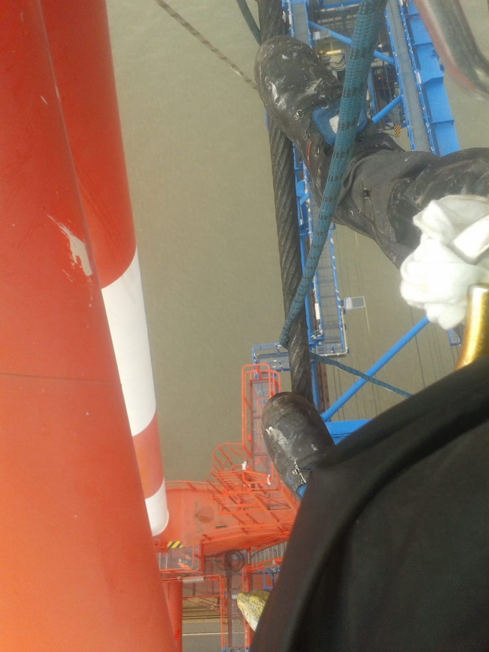 Close-up rappelling inside a crane and ship structure