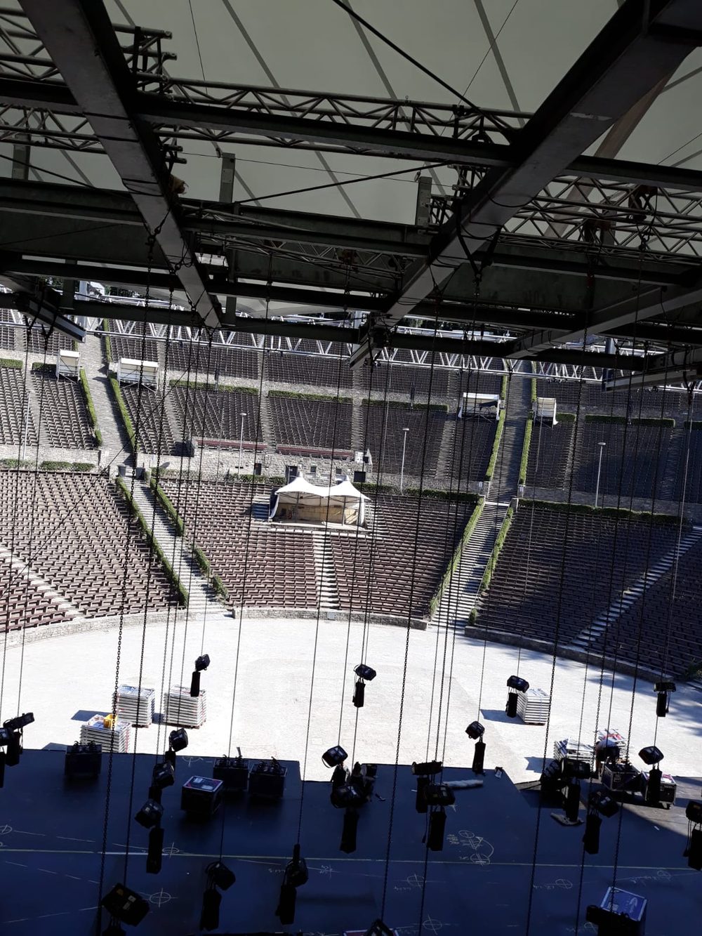 View down over open-air stadium rigging and empty seating